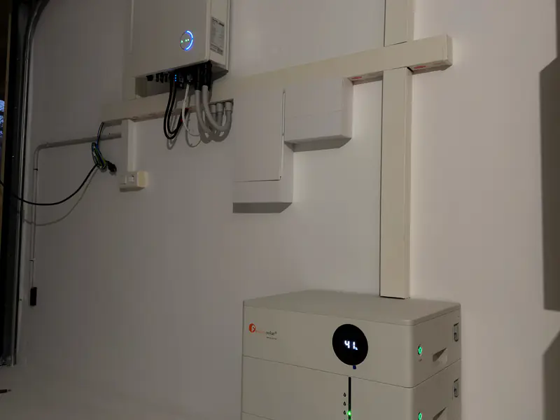 Inversor híbrido y batería de litio instalados por Efitea en la pared de una vivienda