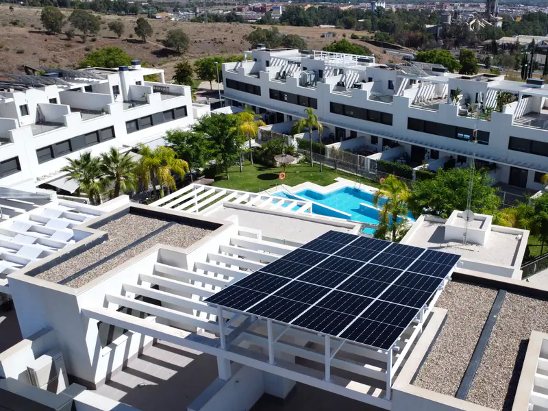 Urbanización con piscina comunitaria y paneles solares de Efitea sobre una azotea