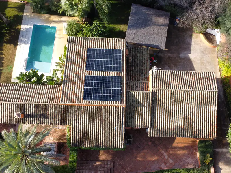 Vista aérea de una vivienda con piscina y placas solares en la cubierta