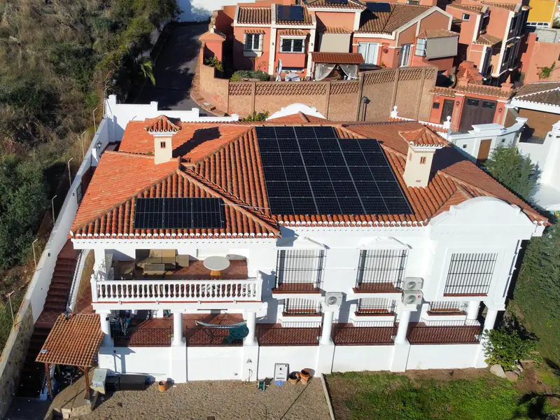 Vivienda blanca con placas solares de Efitea en el tejado de teja